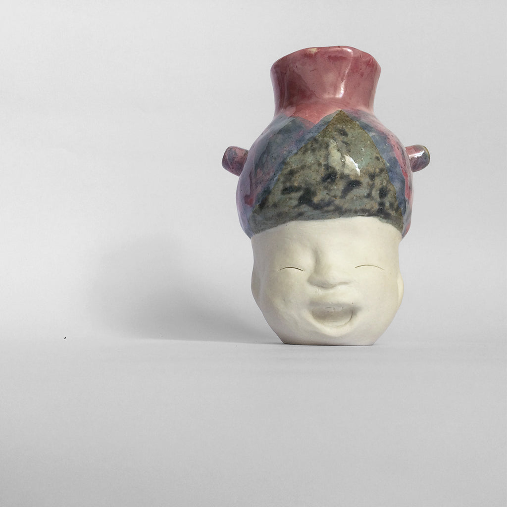 White figurative ceramic sculpture with mixed glazed head facing front