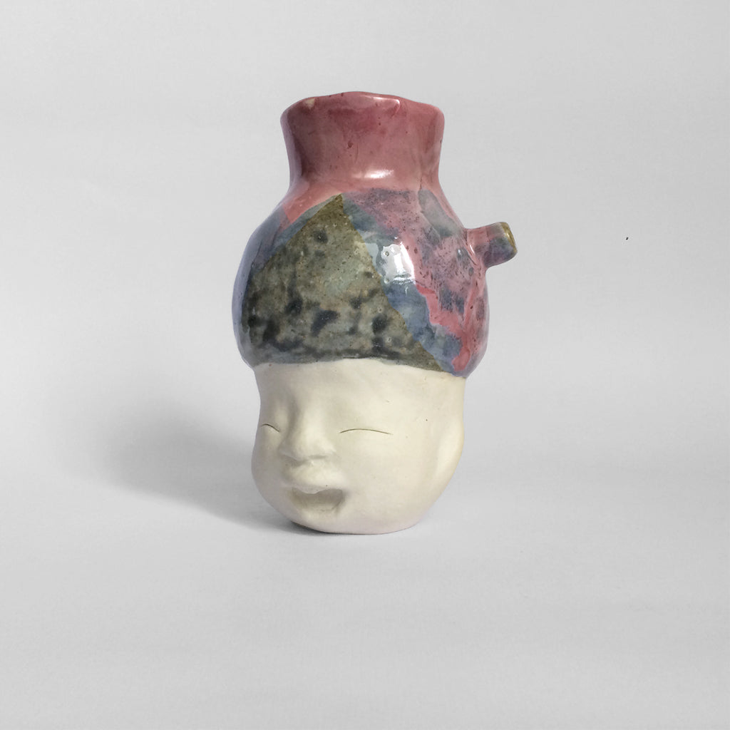 White figurative ceramic sculpture with mixed glazed head facing left.