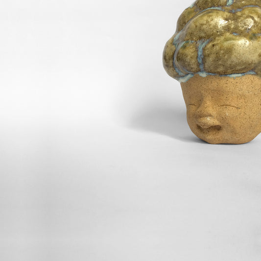 Brown figurative ceramic sculpture with brown glazed head facing left.