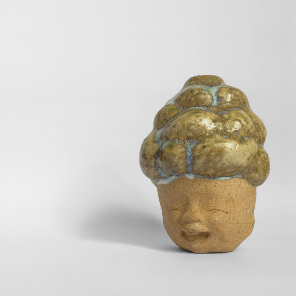Brown figurative ceramic sculpture with brown glazed head facing front.