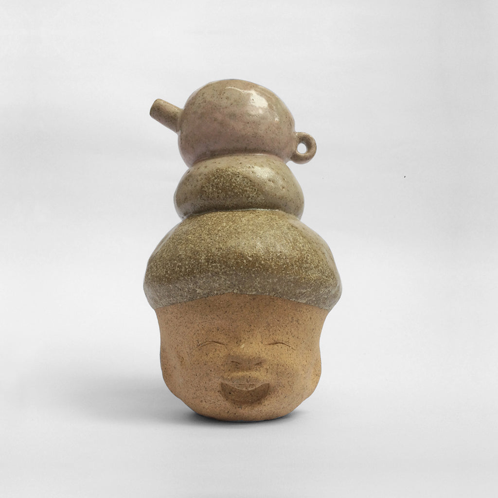Brown figurative ceramic sculpture with greenish brown glazed head facing front.