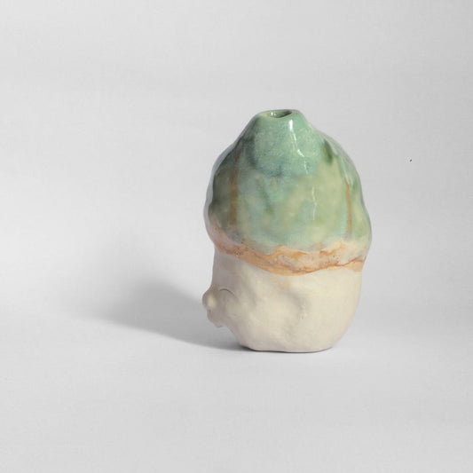 White figurative sculpture with mixed glazed head facing left.