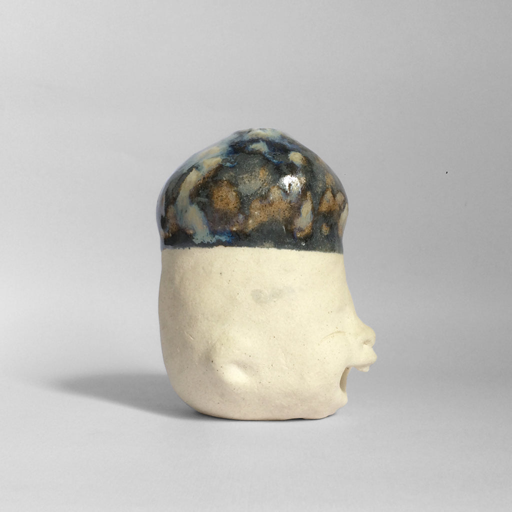 White figurative ceramic sculpture with glazed head.